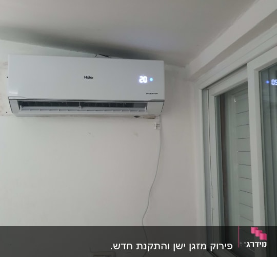 מזגן מותקן על קיר עם תצוגת טמפרטורה 20 מעלות